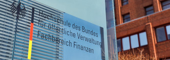 Eingangsschild des Fachbereich Finanzen aus Glas vor einem Gebäude